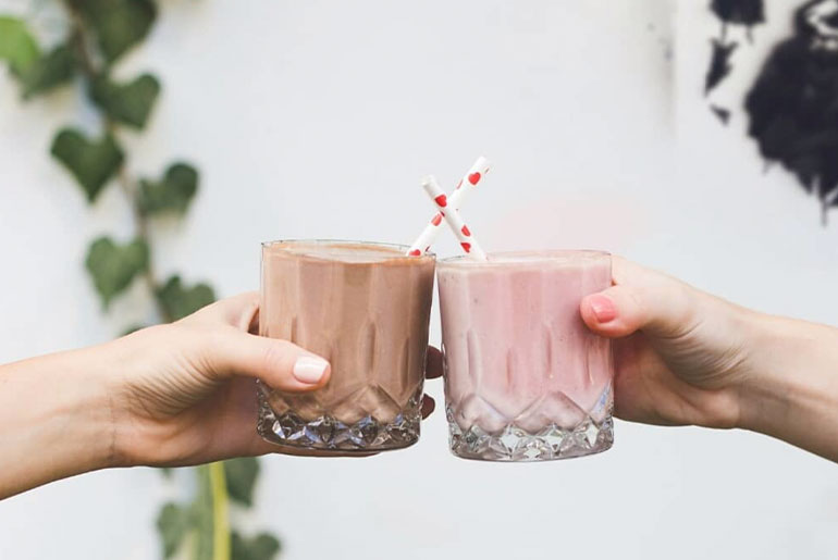 To personer, der står med glas med Formula 1-shake